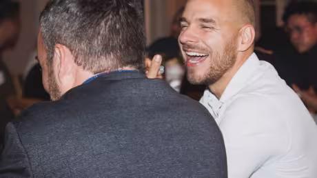 Two men in conversation laughing