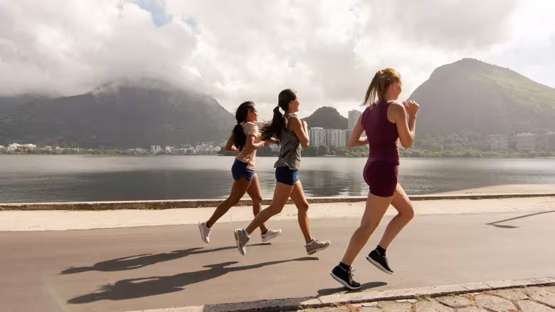 Runners running along the water